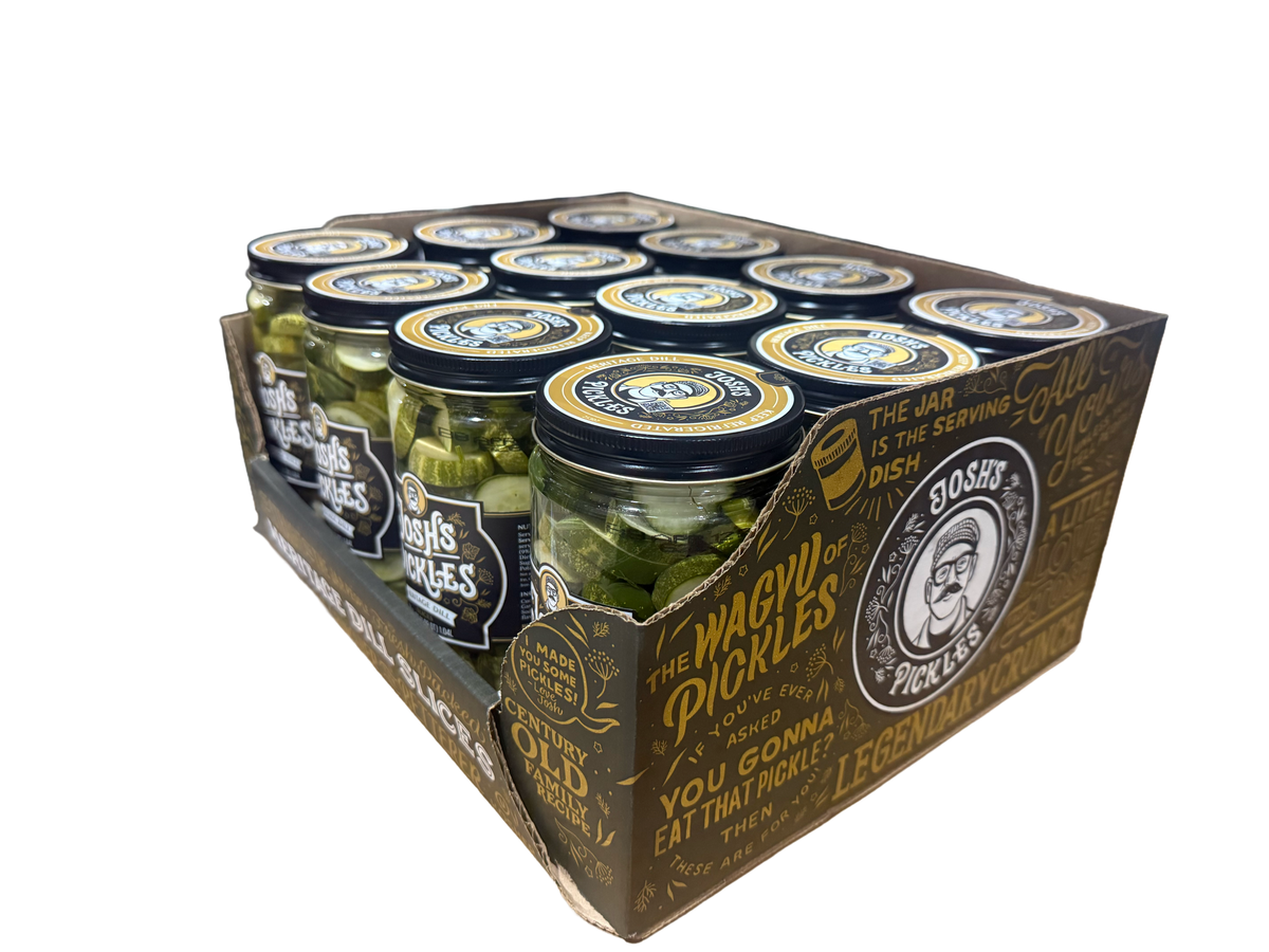 Angled view of a Costco display tray of Josh’s Pickles Heritage Dill Slices 35 fl oz jars, showing the front labels and The Magic of Pickles artwork on the side panel.