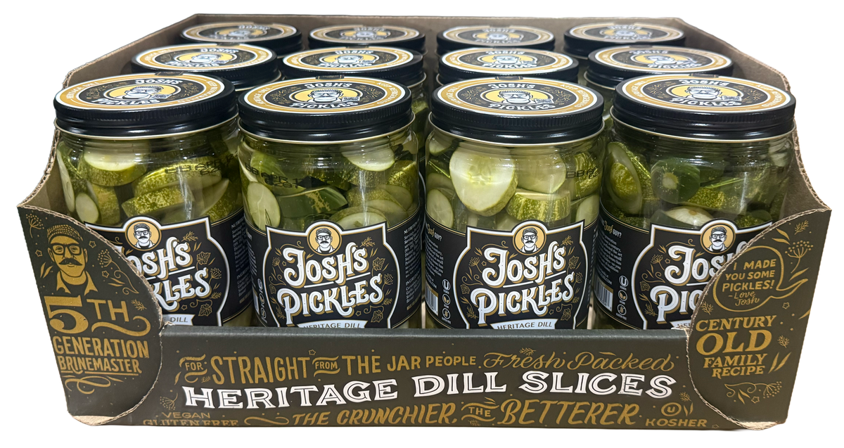 Front view of a Costco display tray holding twelve Josh’s Pickles Heritage Dill Slices 35 fl oz jars, with the front jar labels and branded cardboard tray visible.